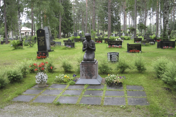 Lapinlahden hautausmaa Yleiskuva hautausmaalta, muistomerkkejä ja hautakiviä sekä nurmialueita niiden välissä.